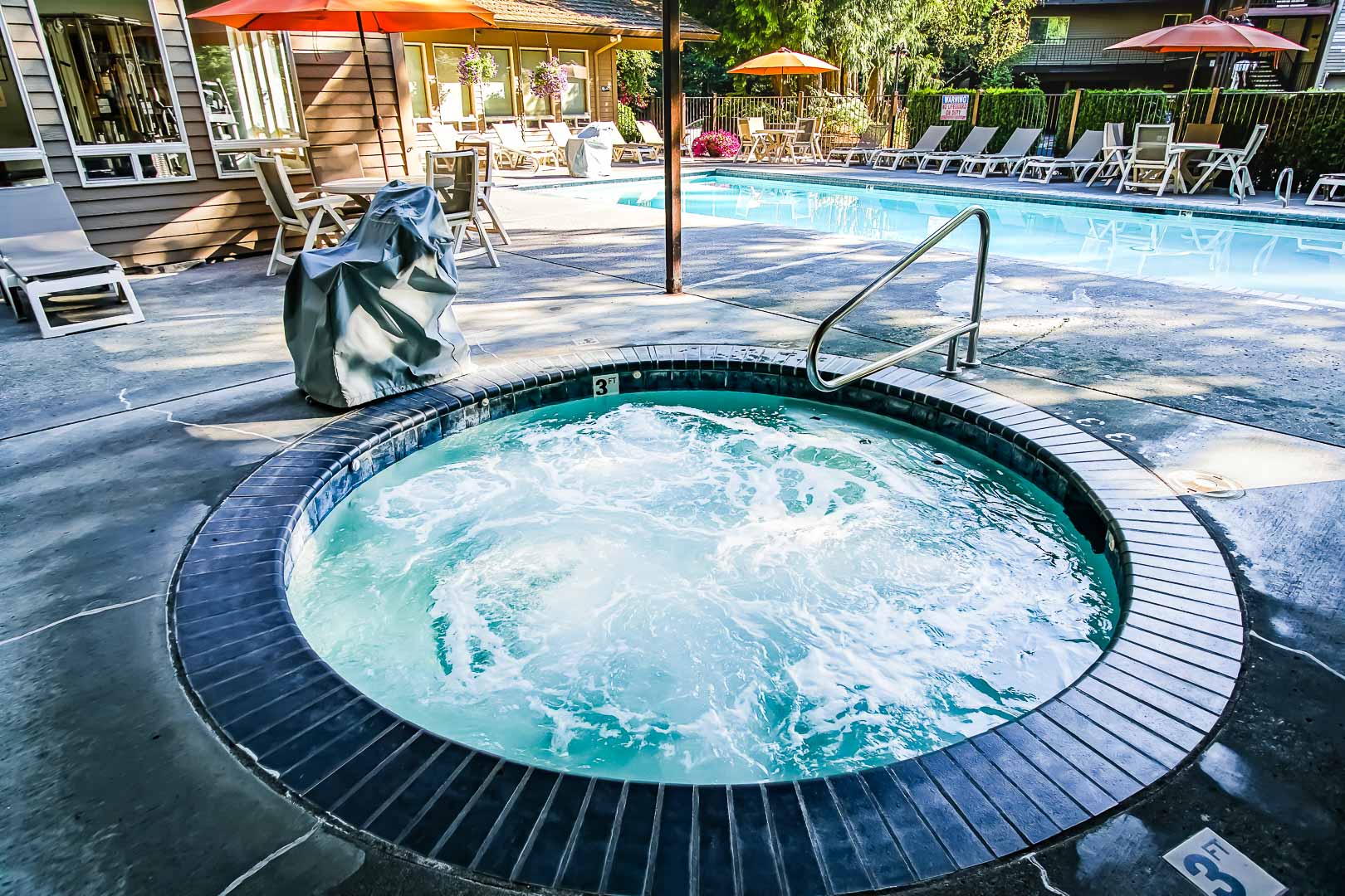 A spacious outdoor swimming pool and a jucuzzi tub at VRI's Whispering Woods Resort in Oregon.